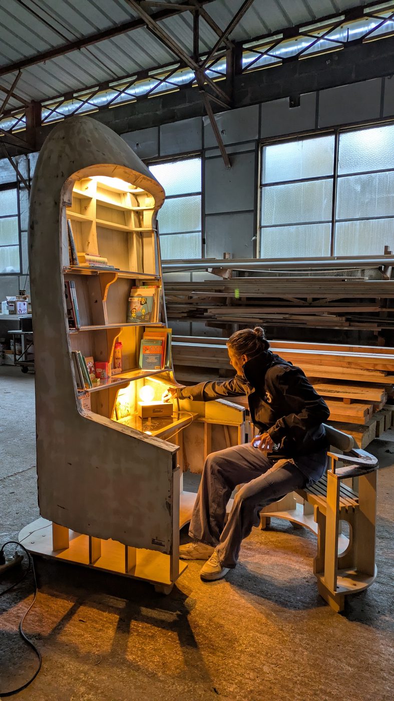La Cabine Bibliothèque éclairée, une personne assise au bureau