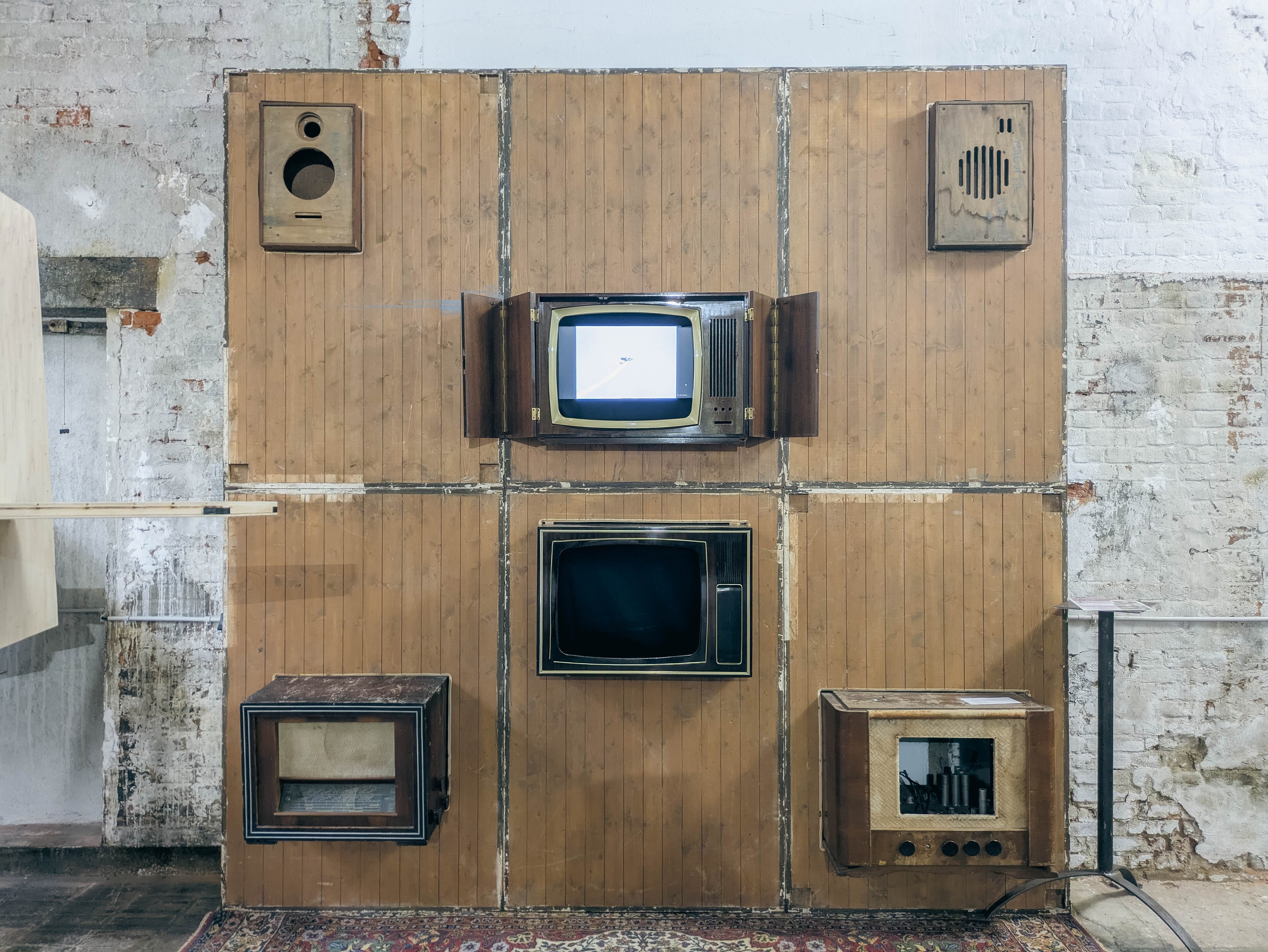 Mur de bois avec téléviseurs, radios et haut-parleurs d’époque